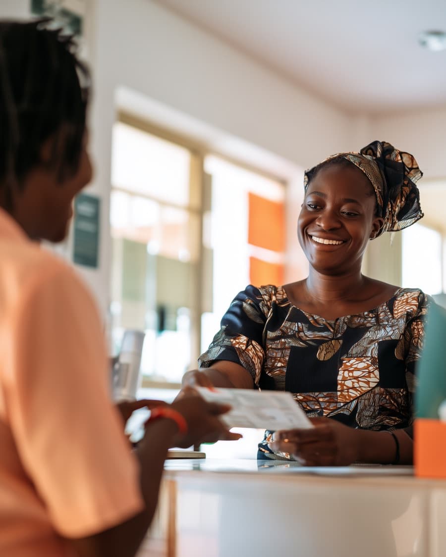 A patient collecting a results envelope at a clinic reception counter
