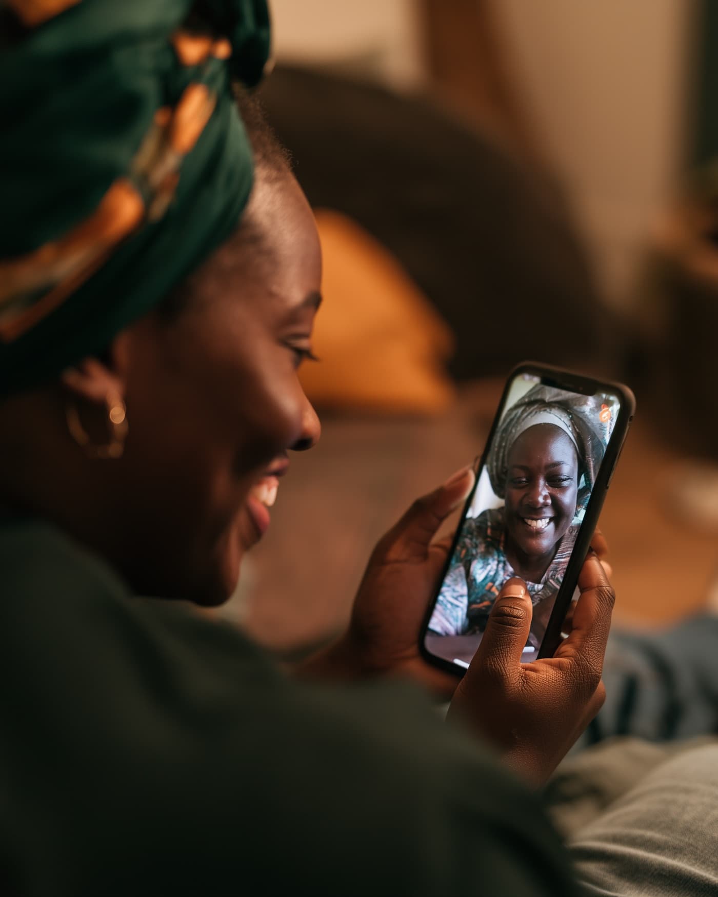 A woman smiling on a video call with her mother